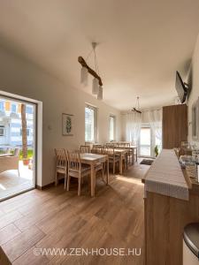 een keuken en eetkamer met tafels en stoelen bij Zen House in Hajdúszoboszló