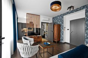 a living room with a couch and a tv at Exclusive Apartments with Private Parking and a Gym in Kraków