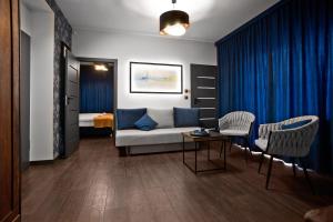 uma sala de estar com um sofá e duas cadeiras em Exclusive Apartments with Private Parking and a Gym na Cracóvia