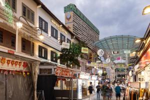 a group of people walking through a shopping street at Heritage Collection on Pagoda - A Digital Hotel in Singapore