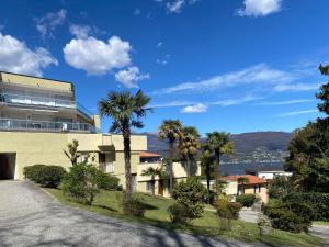 a building with palm trees next to a street at Marconi Lake View in Baveno