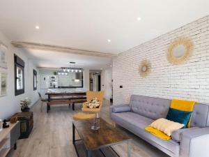 a living room with a couch and a brick wall at Casa Rural El Moradel Añon in Añón