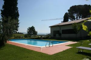 a swimming pool in a yard next to a house at Villa Il Cedro in Petrignano sul Lago