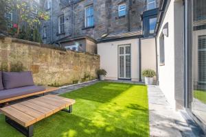 a small backyard with a bench and grass at The Arran, St Andrews in St. Andrews