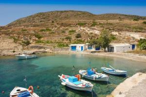 trois bateaux sont amarrés dans une masse d'eau dans l'établissement Apanemo Beach House Agios Nikolaos Kimolos, à Kimolos