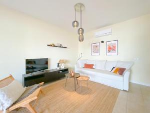 uma sala de estar com um sofá branco e uma mesa em Cozy Retreat for Couples in Burgau no Burgau