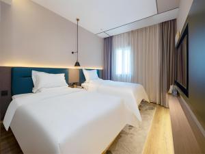 Voodi või voodid majutusasutuse Chaoman Hotel -Guangzhou Shijing City Plaza Xiaoping Subway Station toas