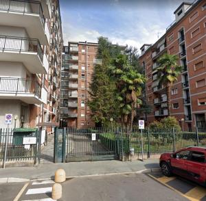 a red car parked in a parking lot next to buildings at Cerro Flat in Cerro Maggiore