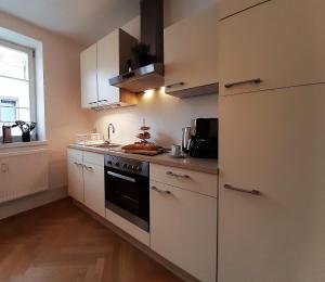 a kitchen with white cabinets and a stove top oven at Apartment 4-6 Personen I 80qm I Altstadt I Dachterasse I Parkplatz in Straubing