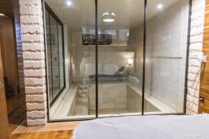 a glass shower in a bedroom with a bed at HOTEL EMROVIC RAJ in Novi Pazar
