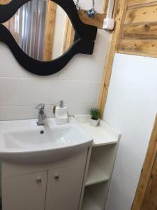uma casa de banho com um lavatório e um espelho em Amur Vendégház em Gárdony