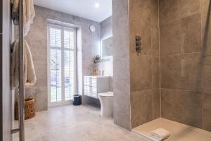 a bathroom with a shower and a toilet and a tub at The Arran, St Andrews in St. Andrews