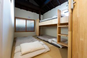 a room with two bunk beds and a ladder at Cafe & Guest House Nagonoya in Nagoya