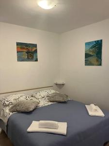 a bed in a room with two pictures on the wall at Mama’s studio in Dubrovnik