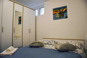 a bedroom with a bed with two pillows and a mirror at Mama’s studio in Dubrovnik
