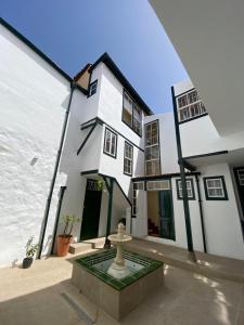 a white house with a fountain in front of it at Double Room, attached bathroom - Casa del Indiano in La Orotava