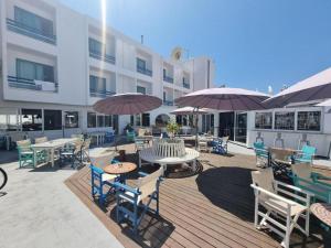 een patio met tafels, stoelen en parasols bij NEREUS HOTEL By IMH Europe Travel and Tours in Paphos City