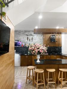 a kitchen with a counter with stools and a vase of flowers at Mina Thien Ha in Da Lat