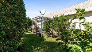 einen Garten mit einer Bank und einigen Büschen in der Unterkunft Little Manly Cottage - Manly Holiday Home in Whangaparaoa