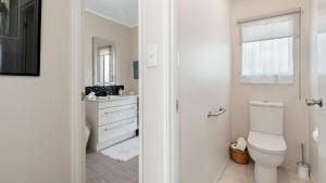 Little Manly Cottage - Manly Holiday Home في وانغاباراوا: حمام أبيض مع مرحاض ومغسلة +11 صورة