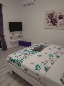 a bedroom with a bed with a floral blanket on it at Dani in Zadar