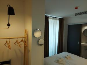 1 dormitorio con cama, espejo y ventana en Bed & Breakfast Mozaik, en Liubliana