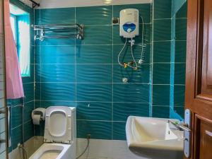 a green tiled bathroom with a toilet and a sink at HÔTEL NOAHGARDEN 2 in Cotonou +65 photos