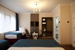 a hotel room with two beds and a table at Genius Hotel Istanbul in Istanbul