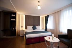 um quarto de hotel com uma cama e um sofá em Genius Hotel Istanbul em Istambul