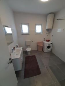 a bathroom with a toilet sink and a washing machine at Dani in Zadar +47 photos
