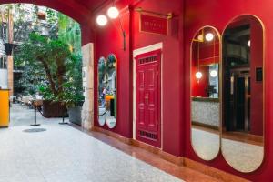 un edificio rojo con dos espejos en el lateral de una calle en Stories Boutique Hotel, en Budapest