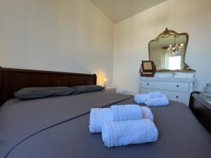 1 dormitorio con 1 cama con 2 toallas en Casa vacanze con vista panoramica, en Frassinello Olivola