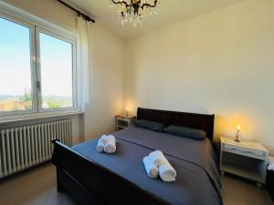 a bedroom with a bed with two towels on it at Casa vacanze con vista panoramica in Frassinello