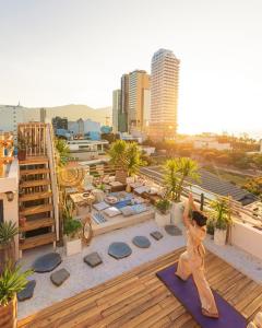 a woman doing yoga on the roof of a building at Sanayen Villa & Residences in Da Nang