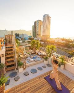 a woman doing yoga on the roof of a building at Sanayen Villa & Residences - Pool and Close Beach in Da Nang