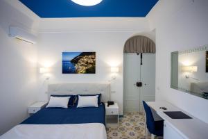 una camera con un letto e un soffitto blu di Locanda Costa D'Amalfi ad Amalfi