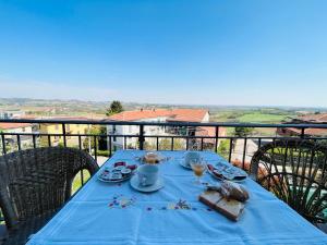 una mesa azul con comida y bebidas en el balcón en Casa vacanze con vista panoramica, en Frassinello Olivola