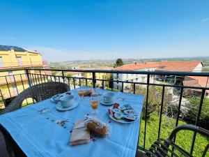 una mesa azul con comida en la parte superior de un balcón en Casa vacanze con vista panoramica, en Frassinello Olivola