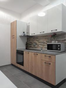 eine Küche mit weißen Schränken und einer Mikrowelle in der Unterkunft Dani in Zadar