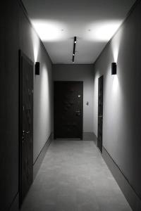 a hallway with two black doors and a hallway with tile floors at NL group apartments in Kolomiya