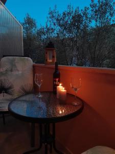 einen Tisch mit zwei Weingläsern, einer Flasche und einer Kerze in der Unterkunft Dani in Zadar