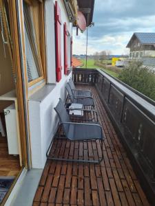 a balcony with two chairs and a table at Sweet Home Ferienwohnung in Ruderatshofen