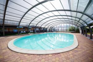 a large swimming pool with a glass ceiling at Glamping the Vosges in Corcieux