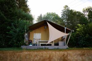 a small yellow tent with a table in front of it at Glamping the Vosges in Corcieux