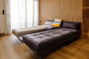 a large leather couch in a room with a window at Goudi 4th Floor Greece Apartments in Athens