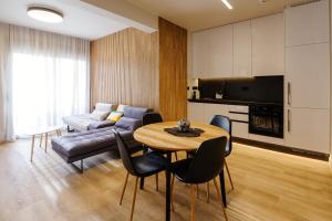 uma sala de estar com uma mesa e um sofá em Goudi 4th Floor Greece Apartments em Atenas