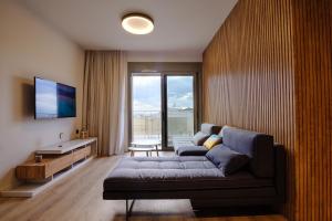 a living room with a couch and a large window at Goudi 4th Floor Greece Apartments in Athens
