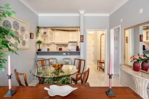 a dining room and kitchen with a glass table and chairs at ALTIDO Vibrant flat with balcony in Costa da Caparica
