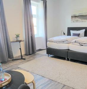 1 dormitorio con 2 camas y mesa en Hotel Alte Post en Dannenberg