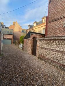 an alley between two brick buildings with a garage at Chambre D'hôte Villa Maurice in Étretat